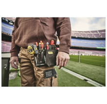 Handwerker mit Werkzeugtasche am Gürtel, gefüllt mit Schraubendrehern und einem Maßband von Stanley