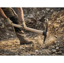 Mann benutzt Spitzhacke zum Graben im Boden