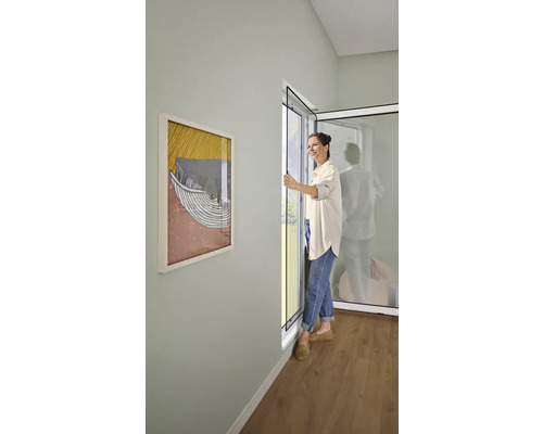 Frau öffnet eine Insektenschutztür in einem hellen Raum.