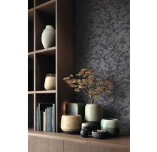 Dekorative Szene mit verschiedenen Keramikvasen und Tapete mit Baumdesign auf einem Holzregal.