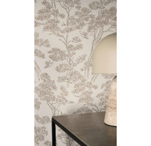 Helle Wohnraumszene mit strukturierter Vliestapete im Kieferndesign an einer Wand hinter einem Tisch und einer Tischleuchte.