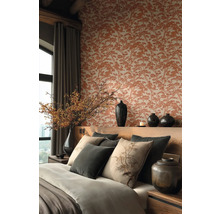 Elegant gestaltetes Schlafzimmer mit Baum-gemusterter Tapete, hölzernem Kopfteil, dekorativen Kissen mit Pflanzenmotiven und dunklen Keramikvasen.