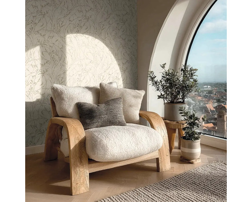 Hell eingerichteter Wohnbereich mit Holz-Sessel, Teddy-Polstern, botanischer Mustertapete, Zimmerpflanzen und großem Bogenfenster mit Stadtblick.