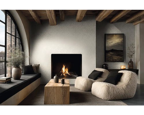 Modernes Wohnzimmer mit Kamin, strukturierten Wänden und Holzbalkendecke. Sessel, ein Holztisch und ein gemütlicher Fensterplatz.