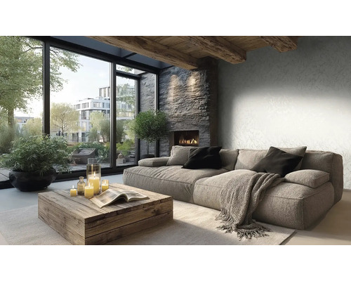 Modernes Wohnzimmer mit gemusterter Vliestapete, grauem Polstersofa, Holztisch, Kamin mit Natursteinwand und großen Fenstern.