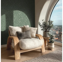 Helles Zimmer mit Sessel, Kissen, Pflanzen und Blick aus dem Fenster