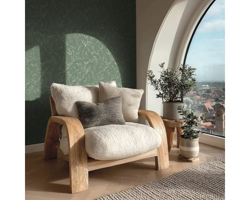Helles Zimmer mit Sessel, Kissen, Pflanzen und Blick aus dem Fenster