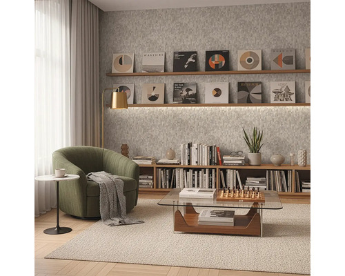 Modern eingerichtetes Zimmer mit grünem Sessel, gläsernem Couchtisch und Holzregalen vor einer grau strukturierten Tapete.