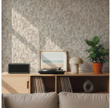Wand mit geometrisch gemusterter Tapete in Beige und Grau hinter einem Sideboard aus Holz mit Plattenspieler und Pflanze in einem hellen Wohnzimmer.