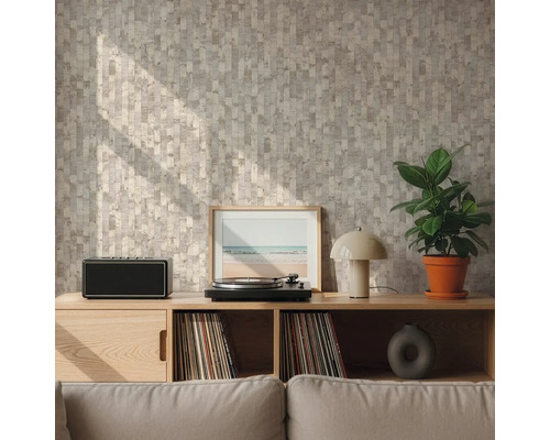 Wand mit geometrisch gemusterter Tapete in Beige und Grau hinter einem Sideboard aus Holz mit Plattenspieler und Pflanze in einem hellen Wohnzimmer.