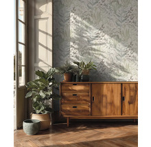 Wohnraum mit gemusterter Tapete, Holzkommode und Zimmerpflanzen für eine helle und organisierte Atmosphäre.