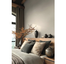 Schlafzimmer mit Bett, Kissen, Vasen und dekorativen Elementen für eine ruhige Atmosphäre