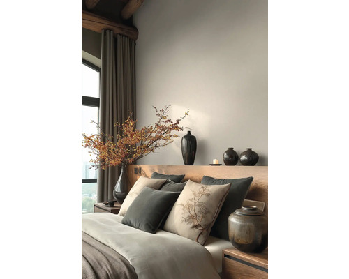 Schlafzimmer mit Bett, Kissen, Vasen und dekorativen Elementen für eine ruhige Atmosphäre