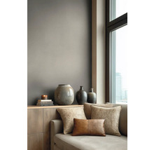 Modern gestalteter Wohnraum mit einer Wand in mattem Taupe hinter einem Sideboard aus Holz mit Vasen und einem Sofa neben einem Fenster.