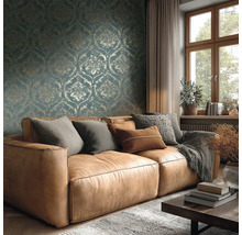Wohnzimmer mit braunem Ledersofa, Kissen, Decke, Holztisch, Fenster und gemusterter Tapete für eine gemütliche Atmosphäre