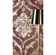 Vliestapete mit barockem Ornamentmuster in Vintage-Optik neben einer goldenen Lampe.