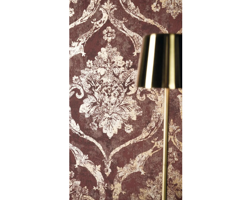 Vliestapete mit barockem Ornamentmuster in Vintage-Optik neben einer goldenen Lampe.
