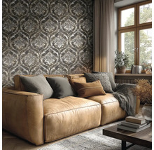 Wohnzimmer mit braunem Ledersofa vor einer dunklen Tapete mit Barock-Ornamenten, großem Fenster und gemütlicher Einrichtung.