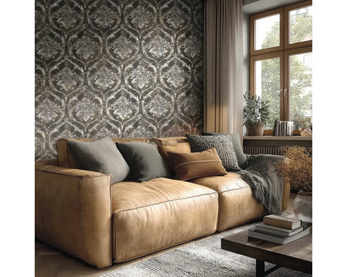 Wohnzimmer mit braunem Ledersofa vor einer dunklen Tapete mit Barock-Ornamenten, großem Fenster und gemütlicher Einrichtung.