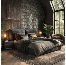 Dunkles Schlafzimmer mit Ornamenttapete, Wandverkleidung aus Holz, Polsterbett, Ledersessel und Teppich im rustikalen Stil.