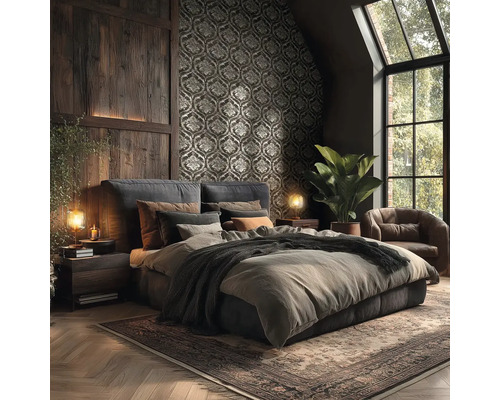 Dunkles Schlafzimmer mit Ornamenttapete, Wandverkleidung aus Holz, Polsterbett, Ledersessel und Teppich im rustikalen Stil.