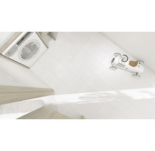 Waschmaschine, weiße Fliesen und ein Spielzeugauto im Badezimmer