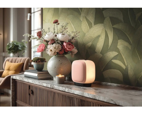 Moderne, quaderförmige Tischleuchte mit sanftem Licht auf einem Sideboard mit Marmorplatte, Blumenstrauß in Vase und Tapete mit Blattmuster.