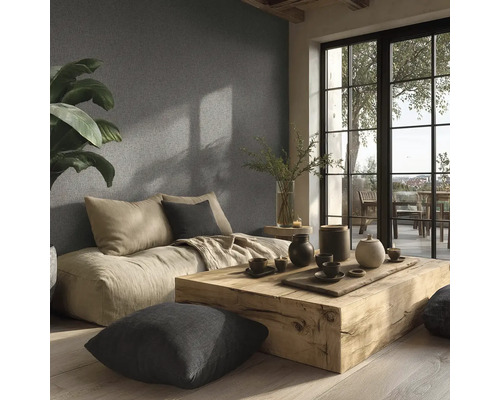 Helles Wohnzimmer mit Sitzkissen, Holztisch und Dekoration vor einer strukturierten Wand