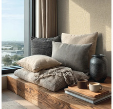 Helle, moderne Fensternische mit Holzbank, verschiedenen Textilkissen, einer Decke, einer Vase und Kaffeetassen auf einem Tablett.
