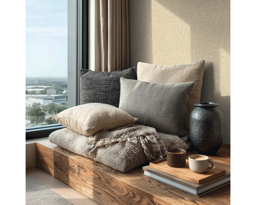 Helle, moderne Fensternische mit Holzbank, verschiedenen Textilkissen, einer Decke, einer Vase und Kaffeetassen auf einem Tablett.