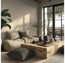 Heller, minimalistischer Wohnbereich mit einem niedrigen Stoffsofa, einem Couchtisch aus einem massiven Holzblock und großen Terrassenfenstern.