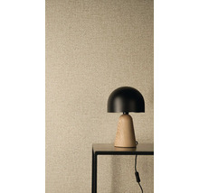 Vliestapete mit Leinenstruktur und Weboptik, im Vordergrund eine moderne Tischleuchte mit schwarzem Schirm und Holzfuß auf einem Metalltisch.