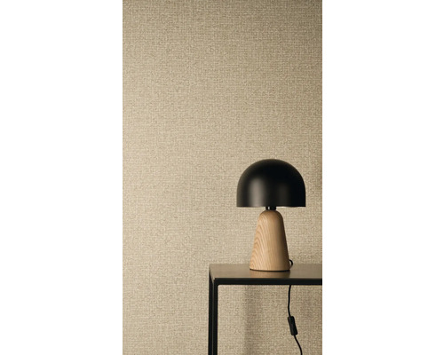 Vliestapete mit Leinenstruktur und Weboptik, im Vordergrund eine moderne Tischleuchte mit schwarzem Schirm und Holzfuß auf einem Metalltisch.