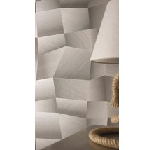 Tapete mit geometrischem Muster, 3D-Effekt und feiner Linienstruktur in einem hellen Zimmer neben einer Lampe.