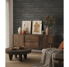 Aufgeräumtes Wohnzimmer mit strukturierter Tapete, einem Sideboard aus Holz, einem runden Couchtisch, dekorativen Vasen und gerahmten Bildern.