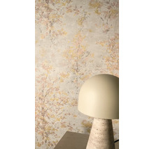 Vliestapete mit impressionistischem Baummotiv in Gold und Rosa auf hellem Hintergrund, kombiniert mit einer modernen Tischleuchte.