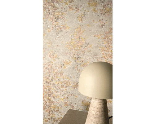 Vliestapete mit impressionistischem Baummotiv in Gold und Rosa auf hellem Hintergrund, kombiniert mit einer modernen Tischleuchte.