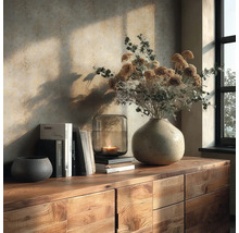 Holz-Sideboard mit Stein-Vase, Trockenblumen, Glas-Laterne mit Kerze und Büchern vor einer strukturierten Tapete in warmem Sonnenlicht.