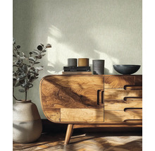 Helle Strukturtapete in einem hellen Raum mit Sideboard aus Holz, Keramikvase und Parkettboden.