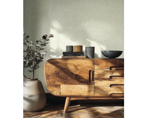 Helle Strukturtapete in einem hellen Raum mit Sideboard aus Holz, Keramikvase und Parkettboden.