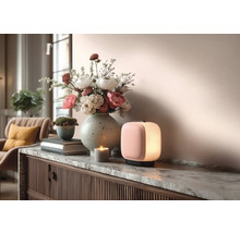 Dekoratives Interieur mit Tischleuchte, Blumenarrangement, Kerze und Kommode