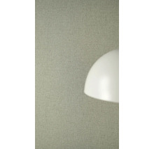 Strukturierte Vliestapete in Leinenoptik an einer Wand hinter einem Lampenschirm.