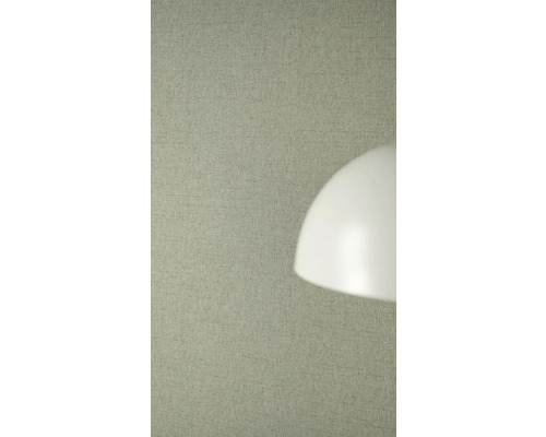 Strukturierte Vliestapete in Leinenoptik an einer Wand hinter einem Lampenschirm.