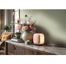 Moderne Wohnzimmerszene mit einer leuchtenden tragbaren Tischleuchte und einer großen Blumenvase auf einem Sideboard mit Marmorplatte.