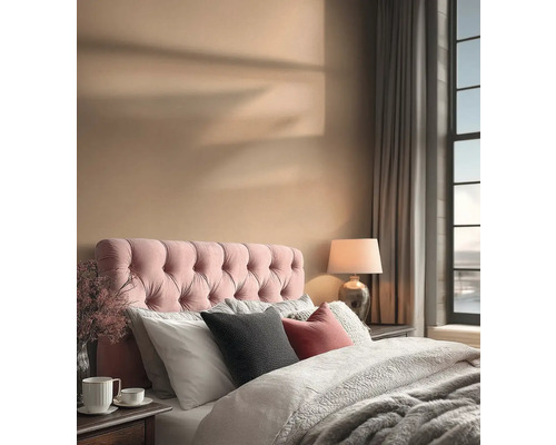 Ein Schlafzimmer mit einem Bett, einem gepolsterten Kopfteil, Kissen, einer Lampe und Vorhängen.