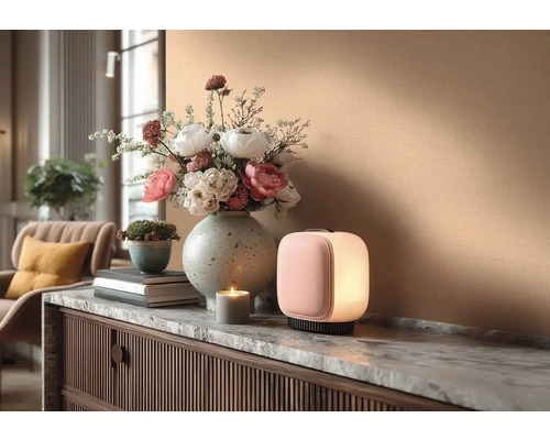 Dekoratives Interieur mit Tischleuchte, Blumenarrangement und Kerze auf einer Kommode.