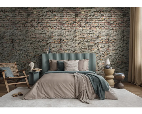 Ein Schlafzimmer mit Backsteinmauer, Bett, Stuhl und Beistelltischen für eine gemütliche Atmosphäre.
