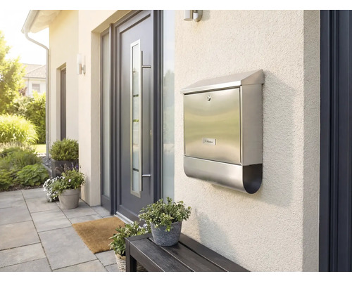 Briefkasten aus Edelstahl an einer Hauswand neben einer Haustür