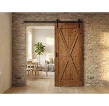 Holzschiebetür im Landhausstil vor einer Backsteinwand