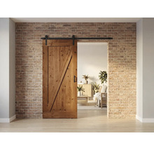 Holzschiebetür mit Beschlägen vor einer Backsteinwand